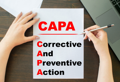 CAPA Corrective and Preventive Action paper with a person's hands holding a pen