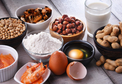 Bowls of food on a table containing allergens. Flour, egg, nuts, peanuts, milk, shellfish, soy