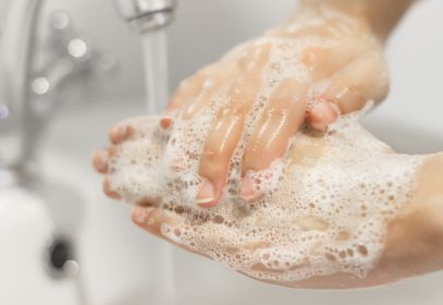 someone washing their hands at a sink with very soapy hands.