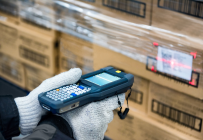 holding a traceability scanning device and aiming it at a barcode in a cold storage facility.