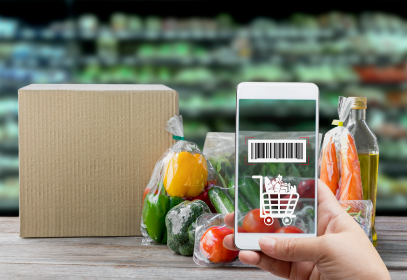 Someone using a phone to scan a produce barcode to demonstrate traceability.