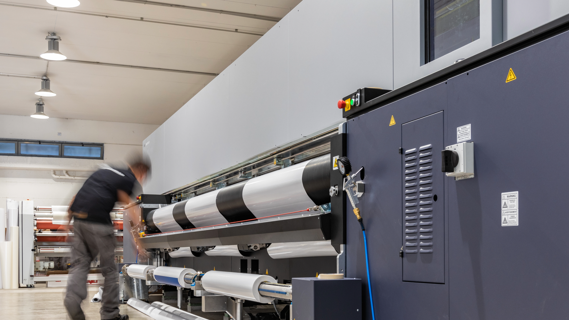 Man adjusting a large format printer at an ISO:2015 certified company