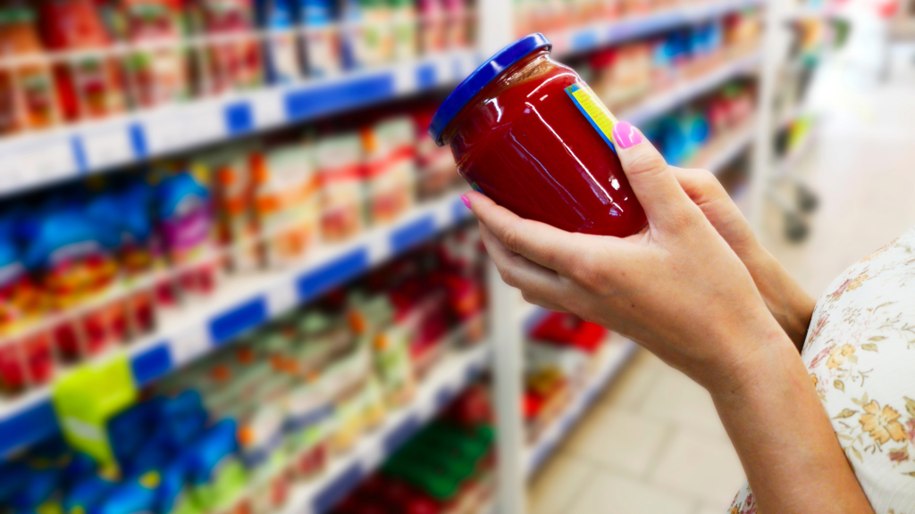 Woman in grocery store reads custom printed label from an ISO certified company.